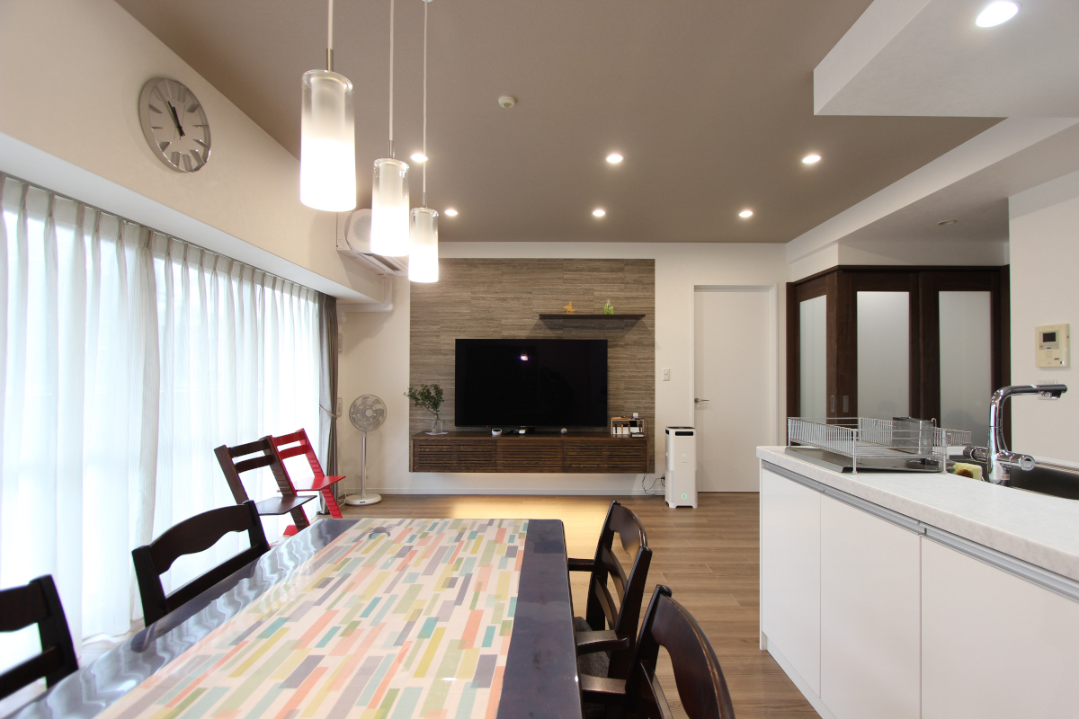 室内の雰囲気に合う既製品のテレビボードを〝浮かせ〟で取り付けることを提案。右の畳コーナーの間仕切りは、閉めても洋室の雰囲気に馴染むダークブラウンとすりガラスのものを採用。