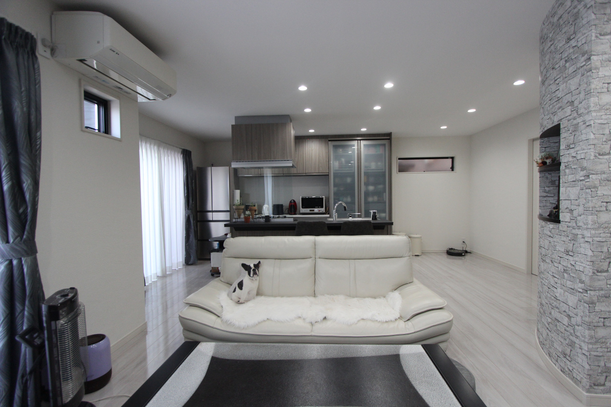 元のLDKと和室の間にあった柱を扇状の壁に。壁の一部をくり抜き、壁のアールに合わせた棚板を造作して飾り棚にしました。